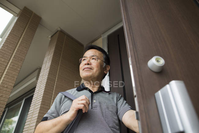 Mann steht vor seiner Haustür. — Stockfoto