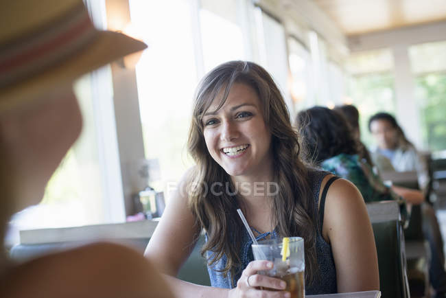 Mujer sentada en una mesa de comedor - foto de stock