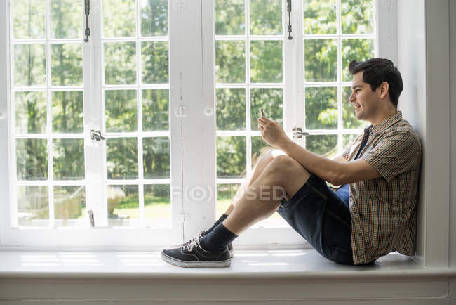 Homem sentado junto a uma janela — Fotografia de Stock