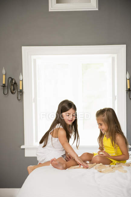 Девочки сидят вместе и играют — стоковое фото