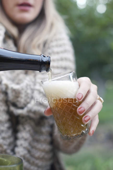 Woman pouring a glass of cider. — Stock Photo