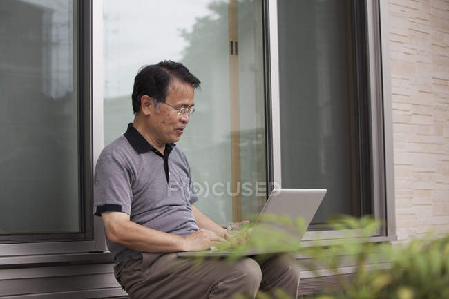 Homme tenant ordinateur portable — Photo de stock