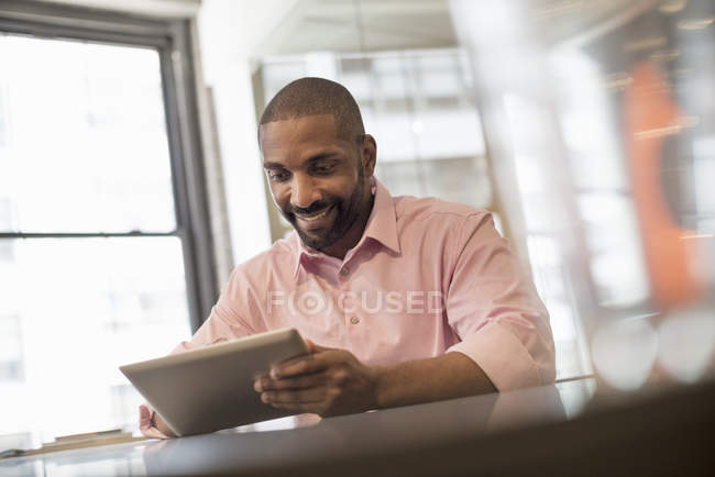 Uomo seduto con tablet digitale — Foto stock