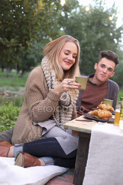Paar sitzt auf dem Boden und isst — Stockfoto