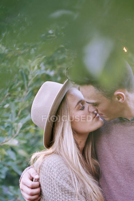Paar küsst sich im Apfelgarten — Stockfoto