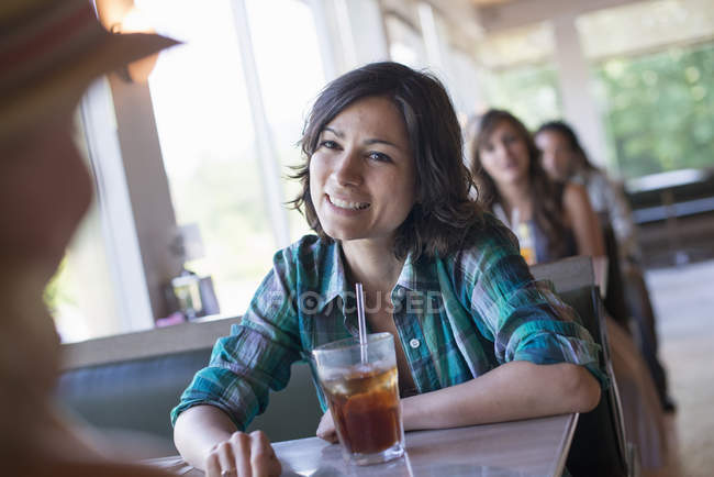 Mulher sentada em um restaurante olhando para seu companheiro — Fotografia de Stock