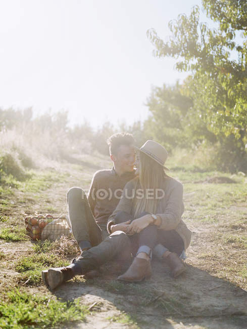 Couple sitting on a sunlit path — Stock Photo