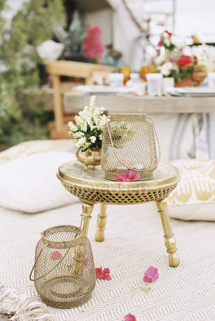 Lanternas e flores em uma pequena mesa de latão — Fotografia de Stock