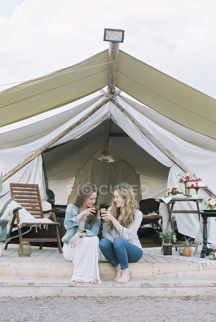 Frauen sitzen vor einem großen Zelt — Stockfoto