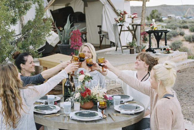 Women enjoying an outdoor meal by tent — Stock Photo