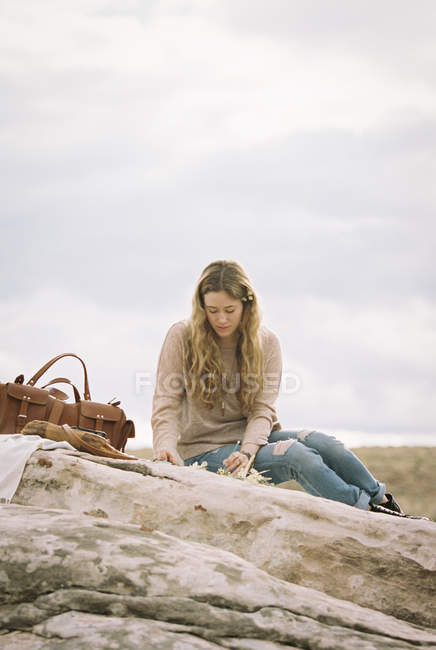 Mulher sentada em uma rocha — Fotografia de Stock
