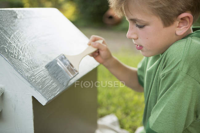 Мальчик рисует собачий домик — стоковое фото