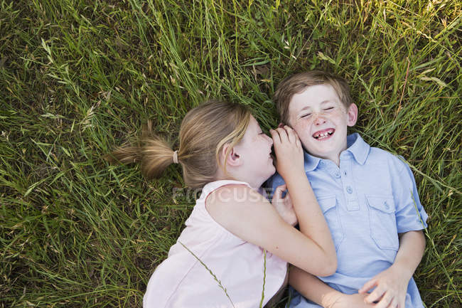 Fratello e sorella sdraiati sull'erba — Foto stock