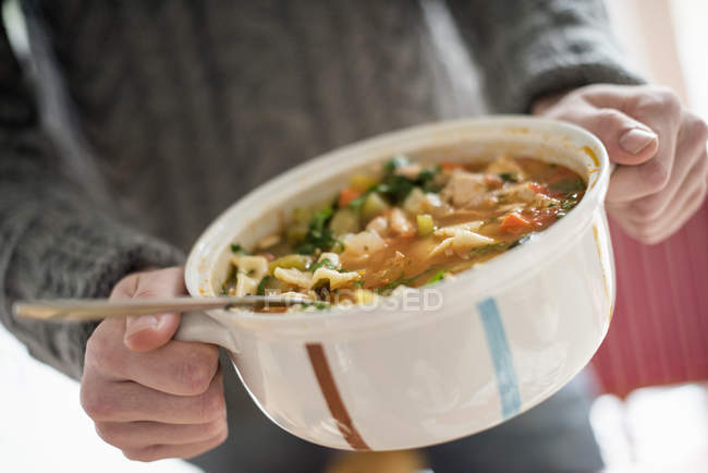 Людина тримає миску з овочевим рагу — стокове фото
