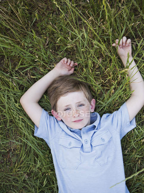 Хлопчик лежить на траві . — стокове фото