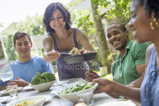 Famiglia che mangia in un giardino — Foto stock