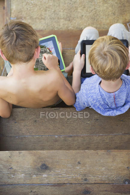 Frères jouant sur des tablettes numériques — Photo de stock
