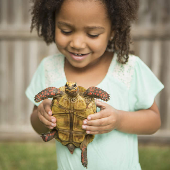 Niño sosteniendo una tortuga - foto de stock