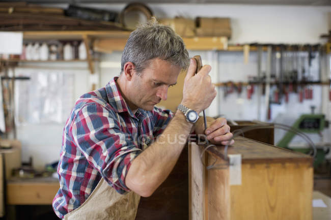 Restaurador de móveis usando uma ferramenta de trabalho portátil — Fotografia de Stock