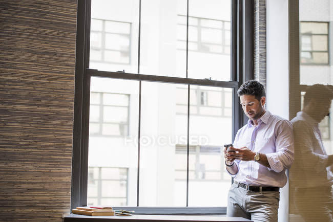 Mann checkt sein Smartphone. — Stockfoto