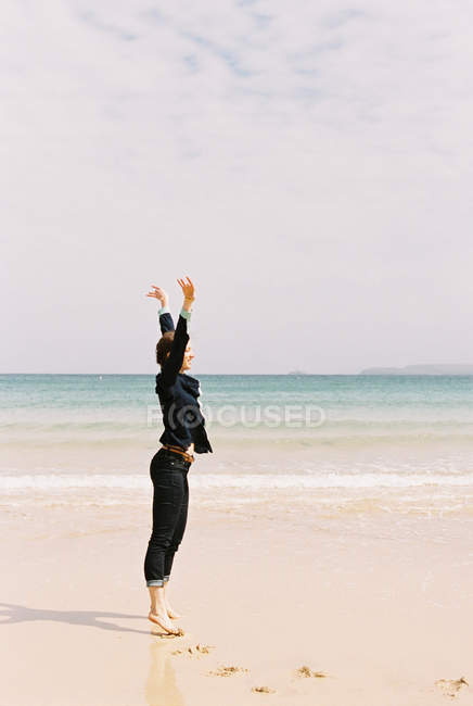 Woman standing barefoot on the sand — Stock Photo