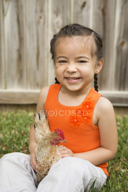 Girl holding a chicken — Stock Photo