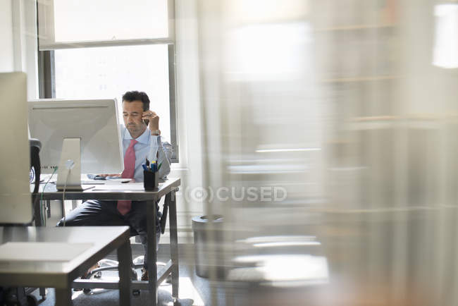 Man seated at a computer screen — Stock Photo