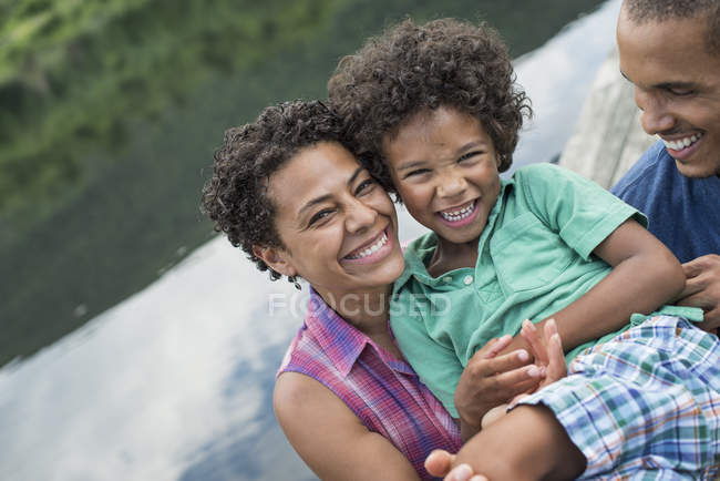 Padres y niño, junto a un lago - foto de stock