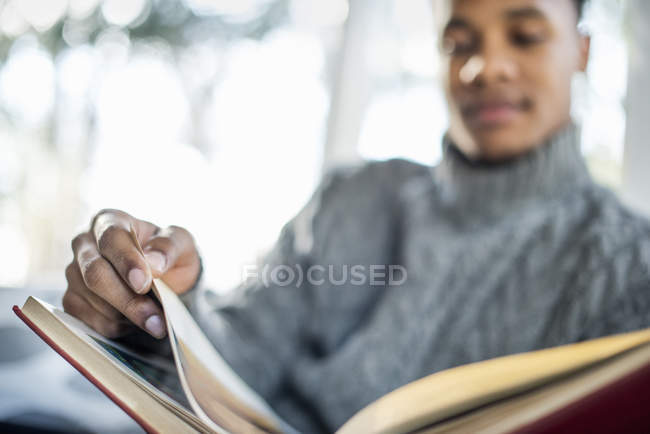 Man flipping through pages of book — Stock Photo