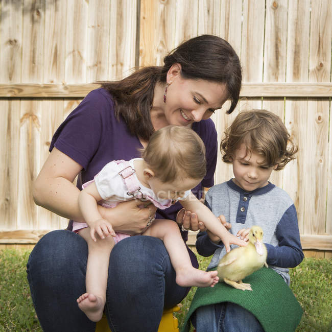 Donna e bambini con anatroccolo
. — Foto stock