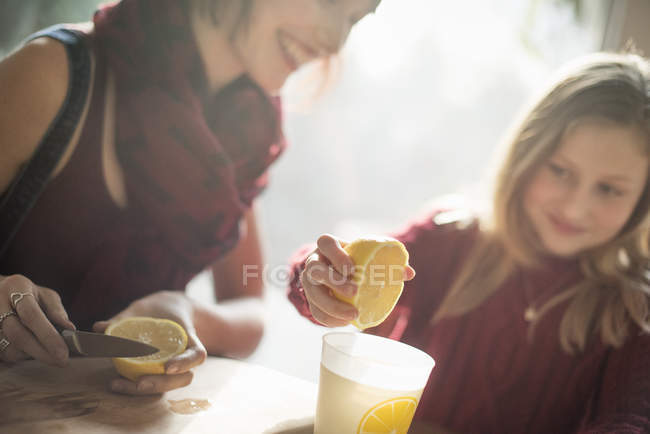 Mujer y niña sentadas a la mesa - foto de stock