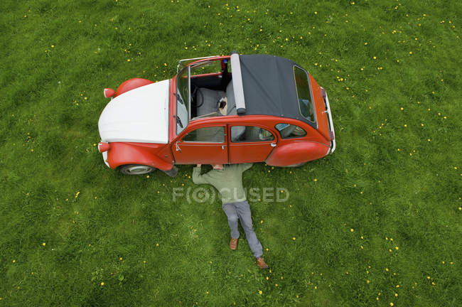 Mann inspiziert die Unterseite des Autos. — Stockfoto