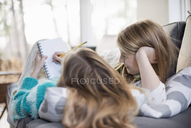 Dos chicas escribiendo en un cuaderno - foto de stock