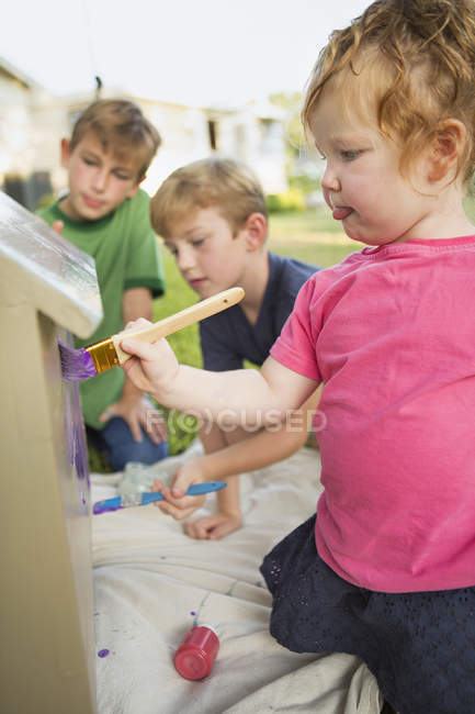 Tres niños pintando casa de perro - foto de stock