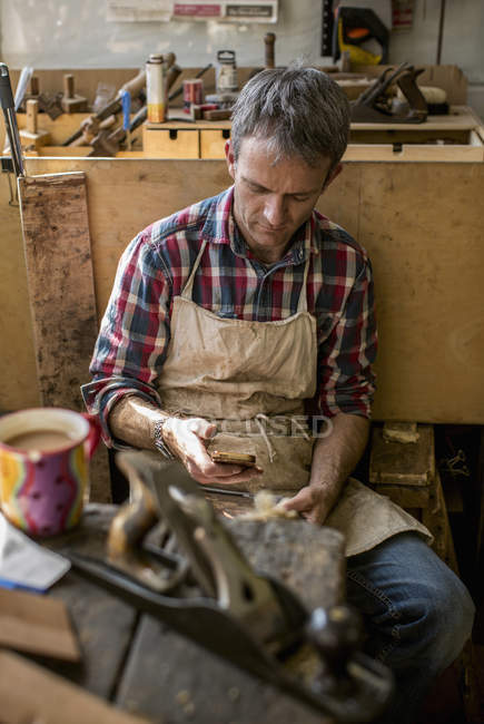 Antique furniture restorer in his workshop — Stock Photo