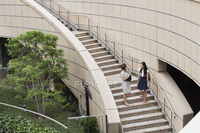 Two women on steps in shopping complex — Stock Photo