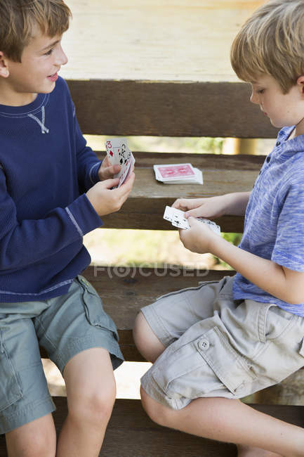 Dos hermanos jugando a las cartas - foto de stock