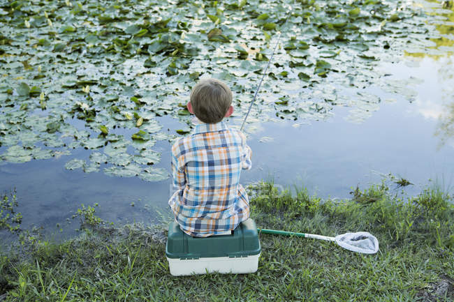 Мальчик рыбачит в реке. — стоковое фото