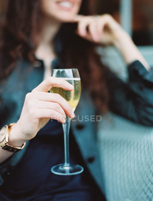Mujer sosteniendo una copa de vino blanco - foto de stock