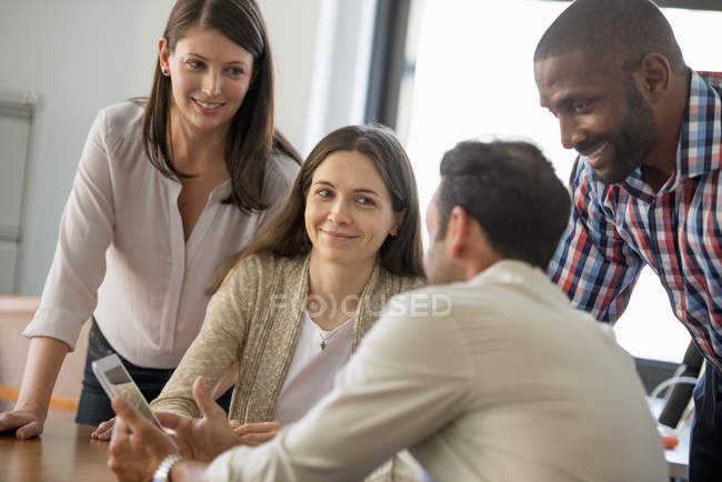 Four people around a digital tablet — Stock Photo