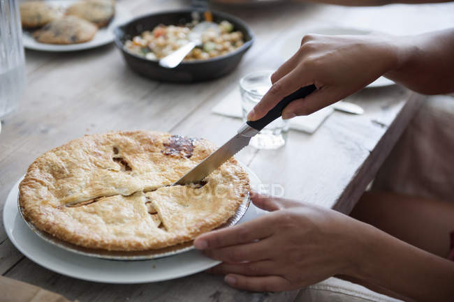 Woman cutting a pie — Stock Photo