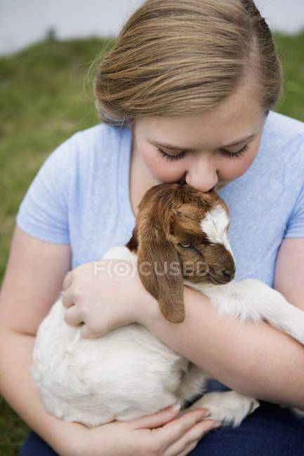 Mädchen kuschelt Ziege. — Stockfoto
