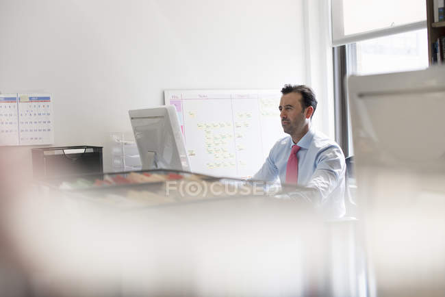 Человек, использующий компьютер в офисе — стоковое фото