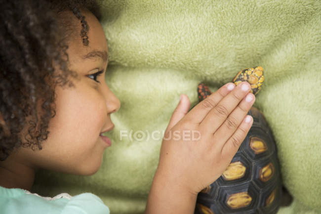 Mädchen schaut eine Schildkröte genau an — Stockfoto