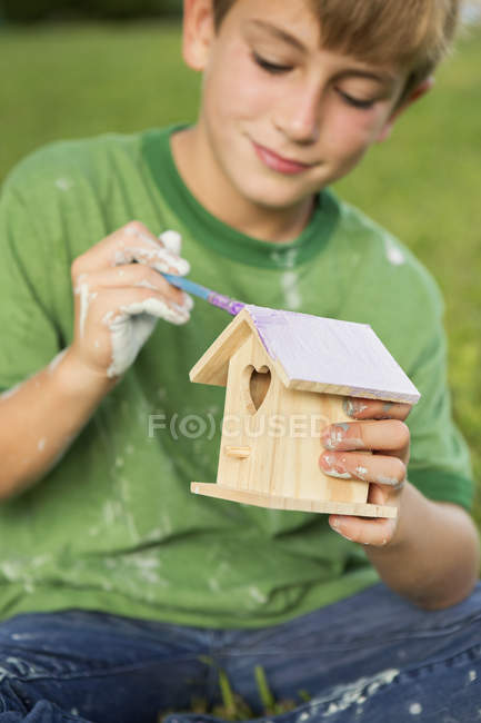 Niño pintura pájaro casa - foto de stock