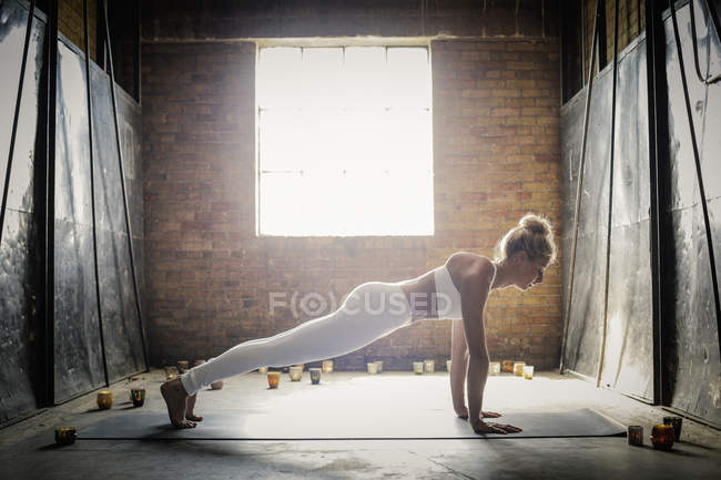Frau macht Yoga umgeben von Kerzen — Stockfoto