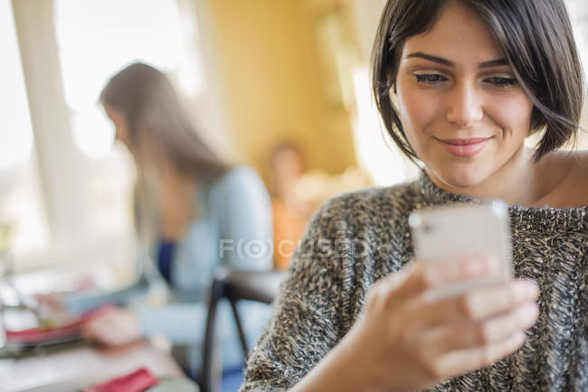 Frau checkt ihr Smartphone — Stockfoto