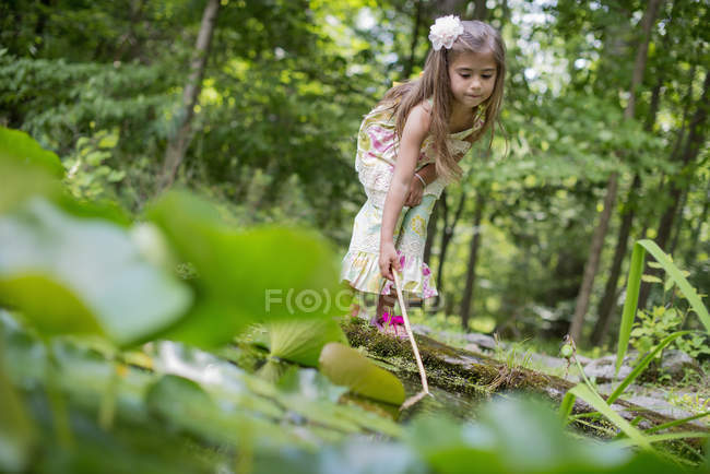 Mädchen spielt an einem Teich — Stockfoto