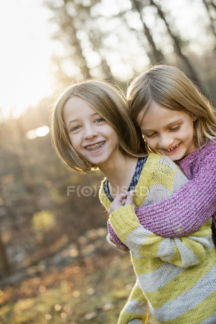 Chicas sonrientes abrazándose - foto de stock