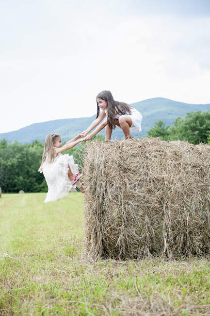 Девушки играют на большом сене — стоковое фото